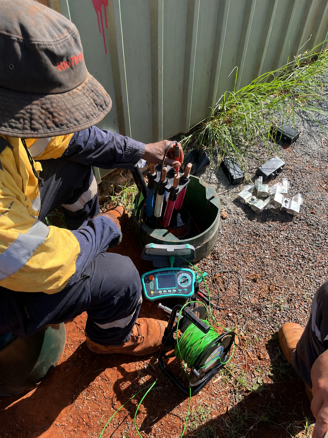 Electrician testing high-voltage cabling on an industrial site